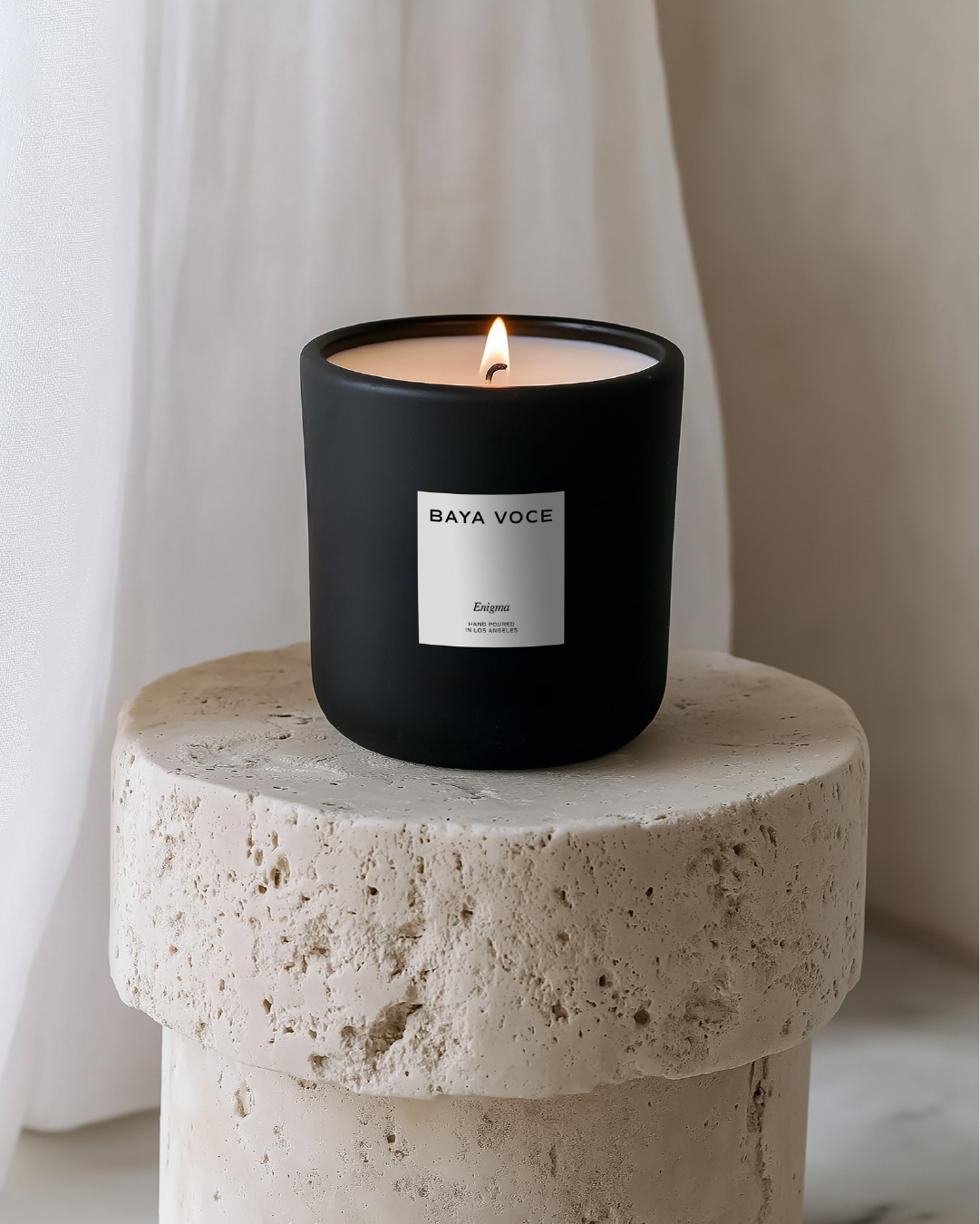 Matte black candle labeled ‘Enigma’ designed for Baya Voce, representing a signature scent concept as part of her immersive brand experience.