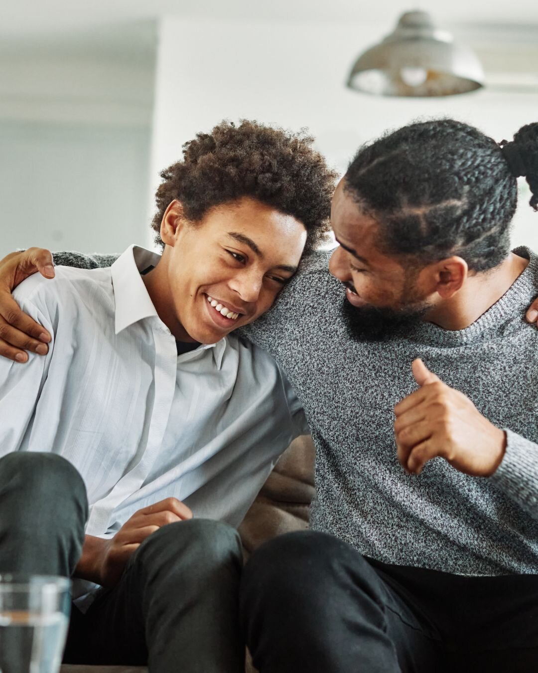 Father and teenage son laughing together.