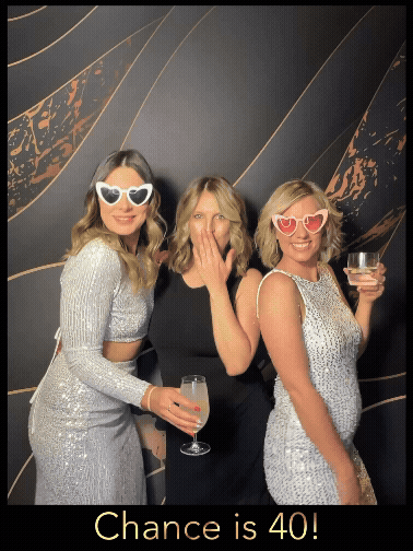 three girls glammed in black gold and silver in a photo booth capture in christchurch with heart sunglasses