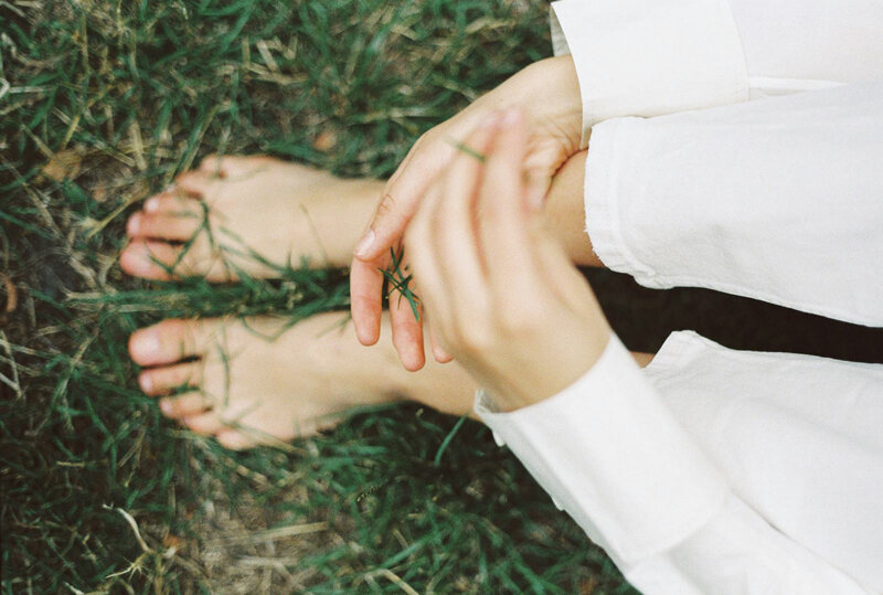 person sitting and playing with grass