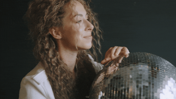Woman with a mirror ball smiling