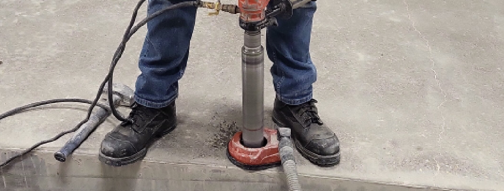 An operator using a concrete core drill