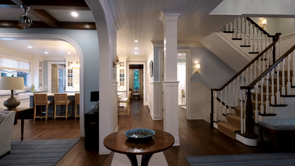 A stunning custom home entryway leading to a kitchen featuring dark wood floors and a striking baby blue oven range. The elegant contrast between the warm wood and bold appliance adds a unique and stylish touch to this beautifully designed space.