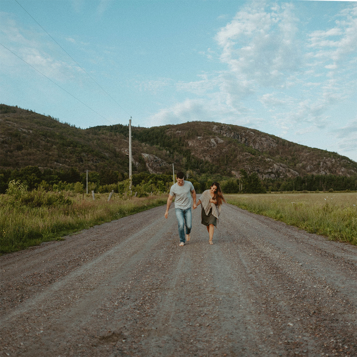 couple running toward camera on dirt road