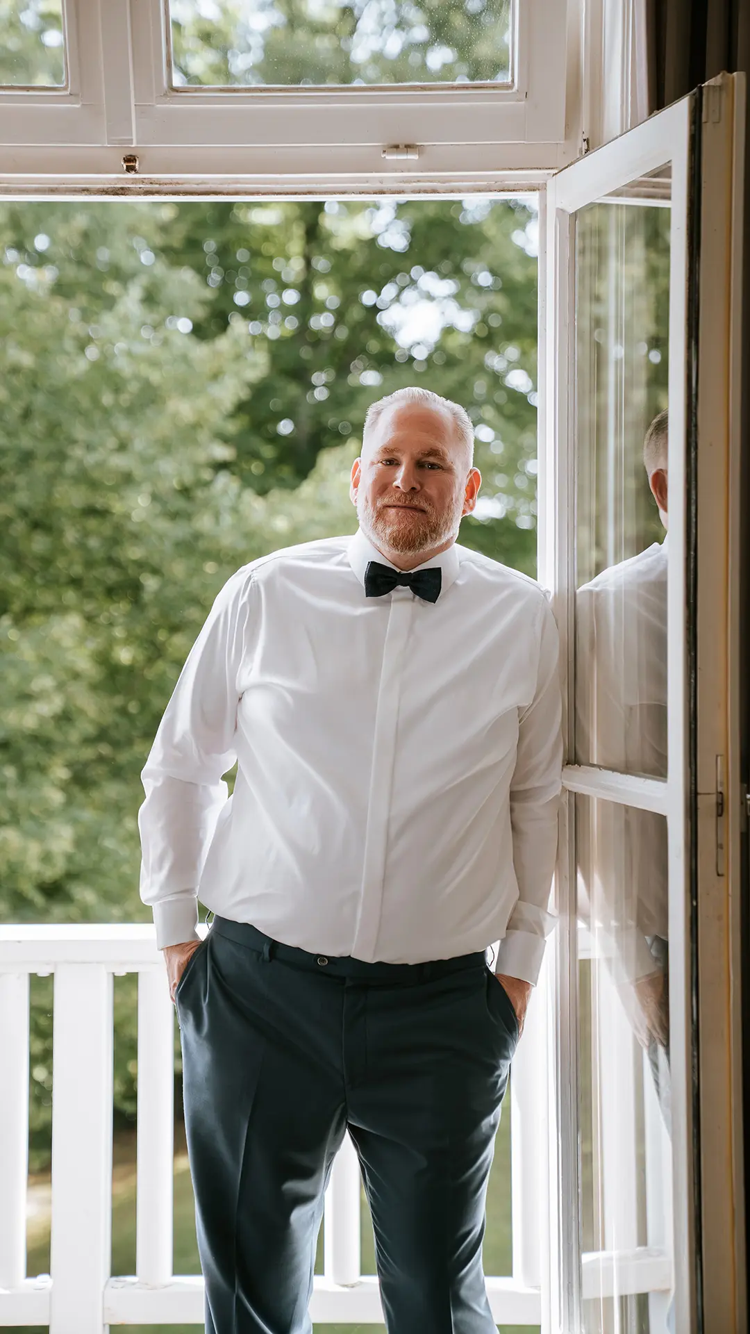 Fotograf Hochzeit Hamburg – Bräutigam beim Getting Ready an der Balkontür im Elsa Brändström Haus.