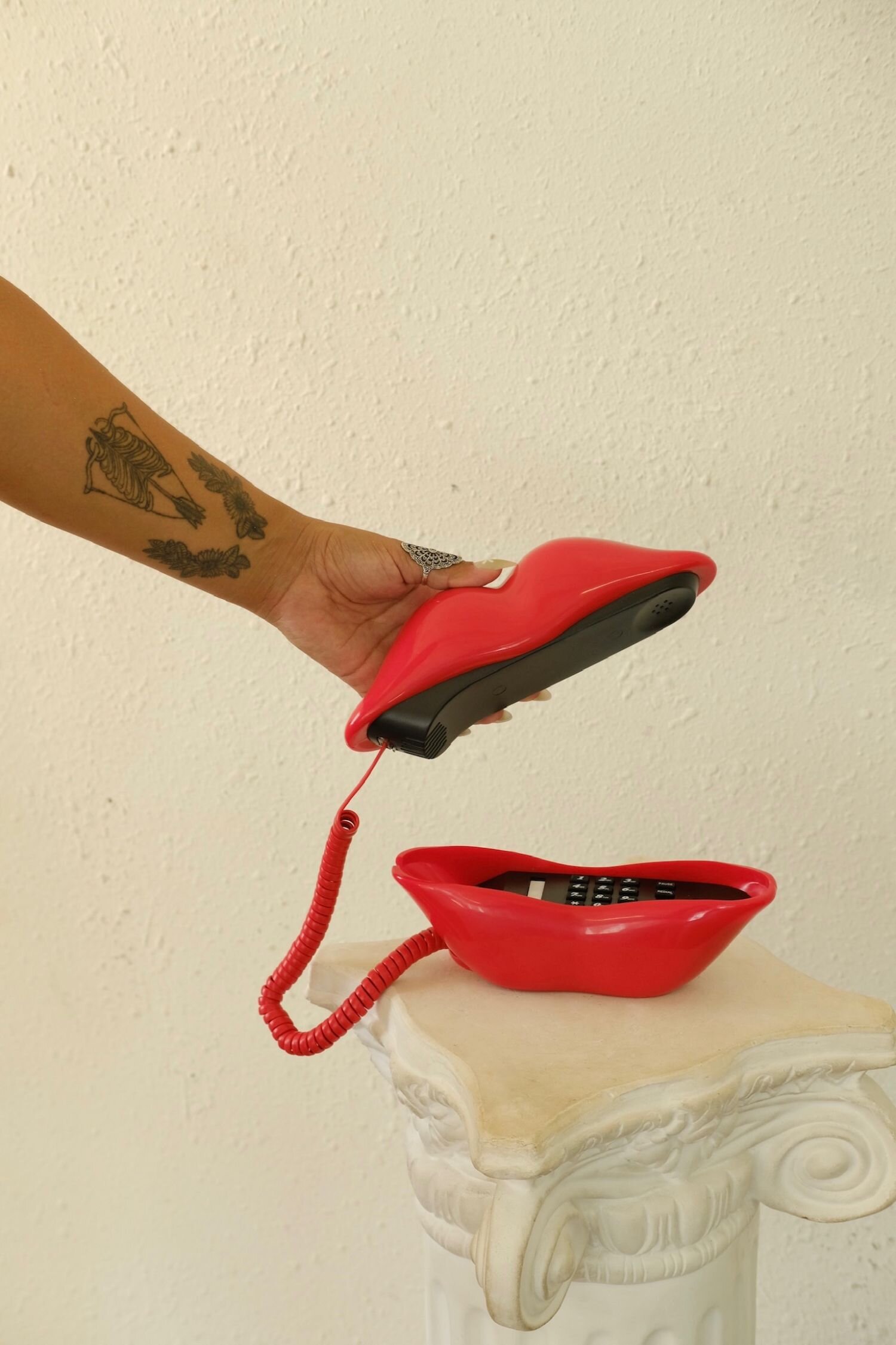 website designer hand answering lips shaped old school telephone