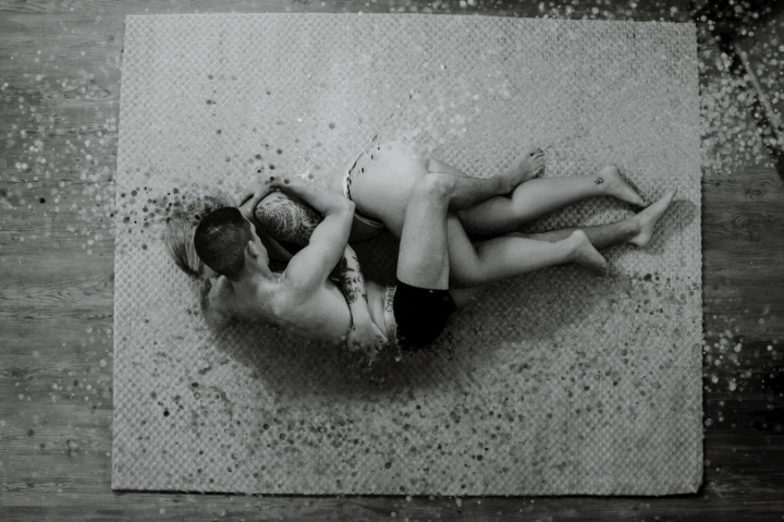 aerial view of couple lying on rug in underwear embracing . graphic added for pieces of couple breaking apart and coming back together.