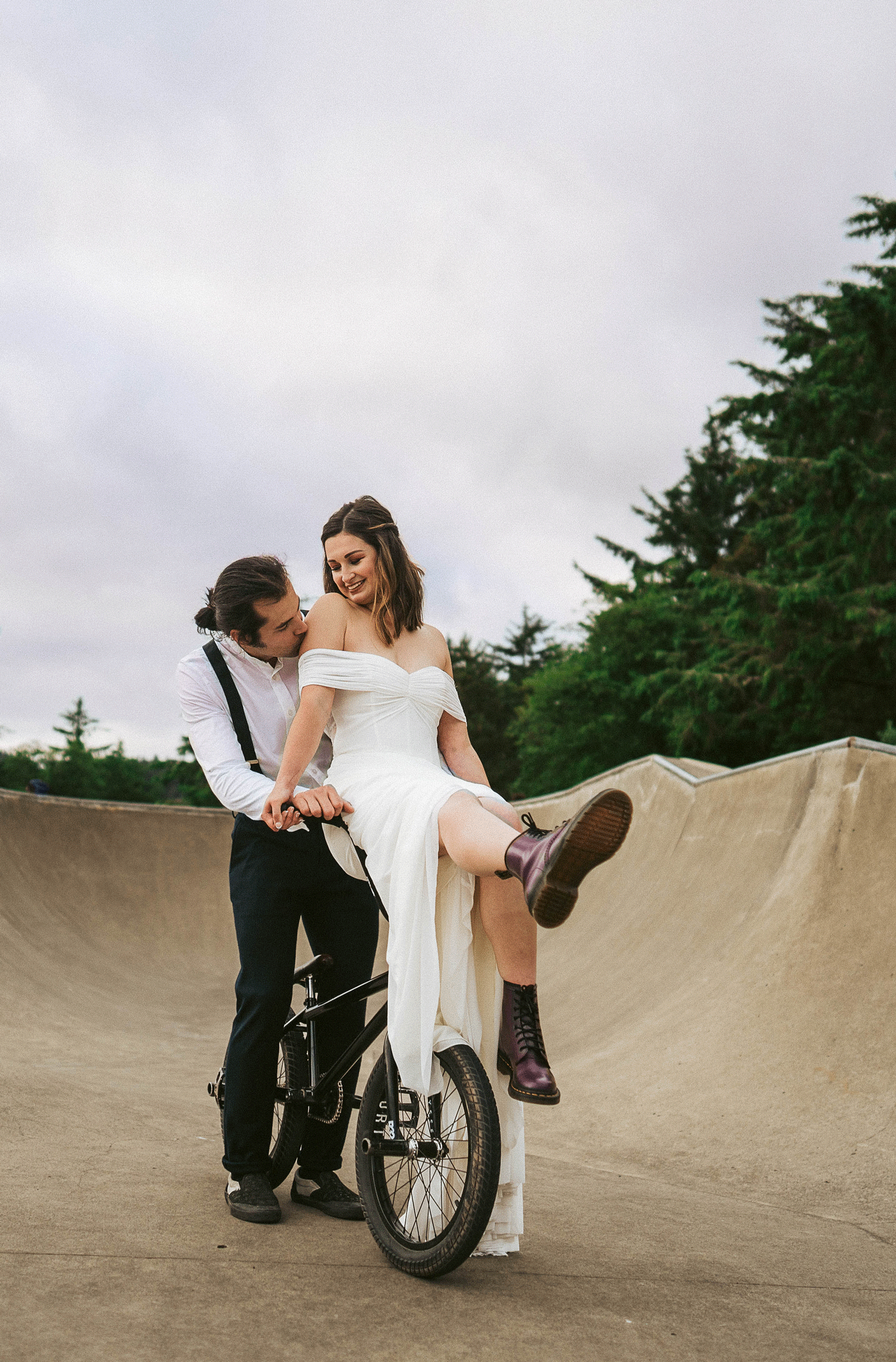elopement bride sits on BMX bike as they  celebrate their Cannon Beach destination elopement