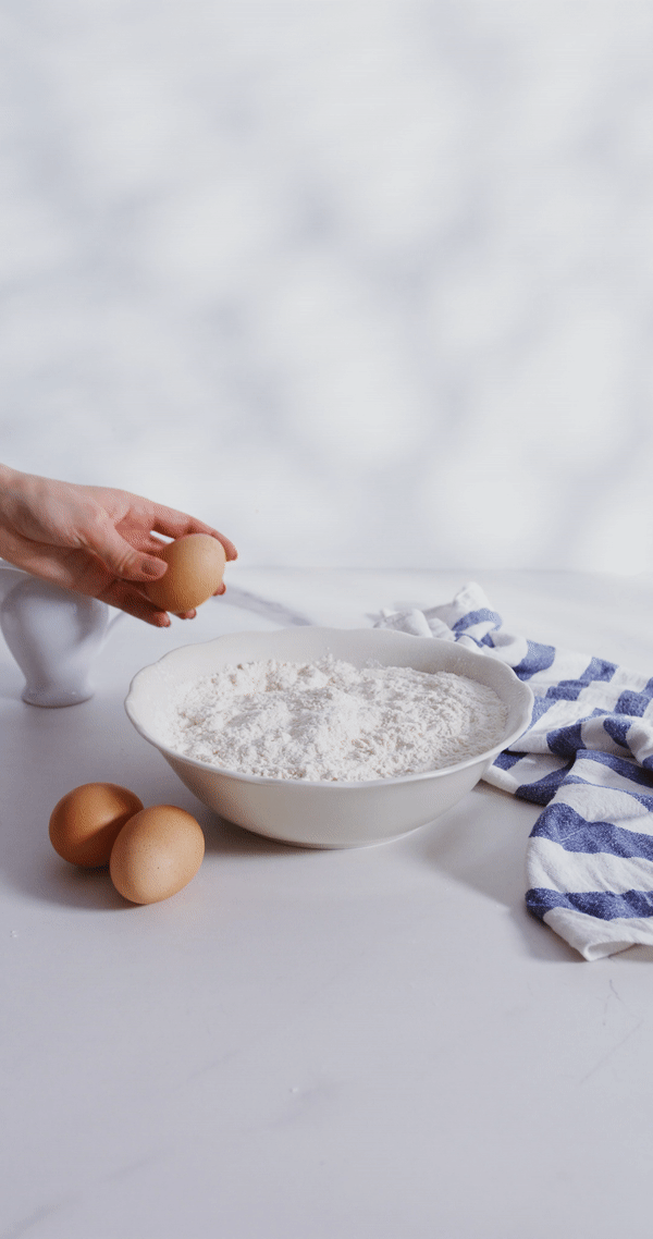 An animated sequence of an egg being cracked into a bowl of flour, representing the beginning of a nutritious recipe preparation.