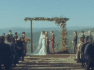 Bride and groom sharing their first kiss during the wedding ceremony, captured in a candid, photojournalistic style with a mix of digital and film photography, showcasing an authentic and emotional moment