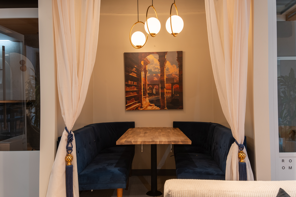 Delphi — banquette seating with warm lighting and artwork