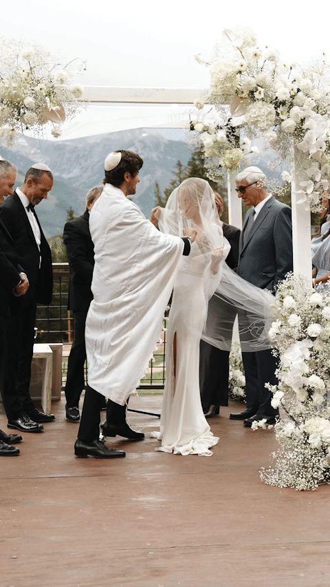 gif of couple at the alter. person in suit removes their partner's veil and kisses them