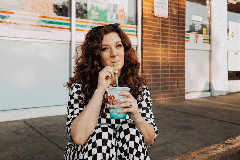 A GIF of a woman swaying back and forth sipping a slurpee.