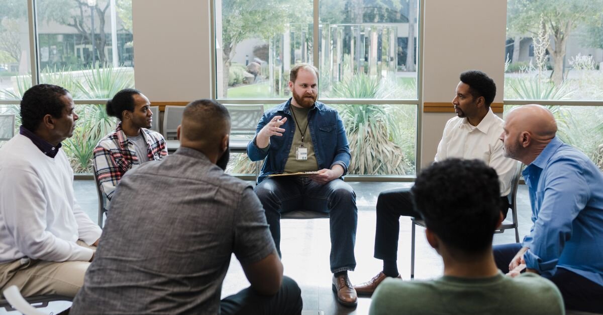Men participating in a group therapy conversation