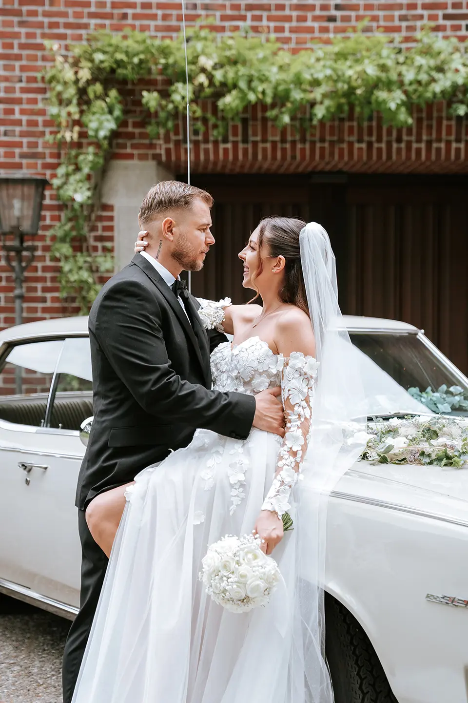 Braut und Bräutigam küssen sich am Strand vor ruhiger See; fotograf für hochzeit am strand liefert hochzeitsbilder draußen und kreative Hochzeitsfotografie Hamburg