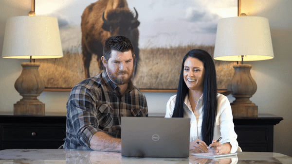 man and woman looking at a computer and laughing