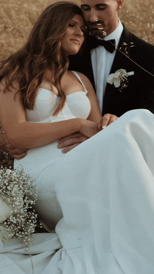 Bride draped in her veil, holding her boquet of white roses