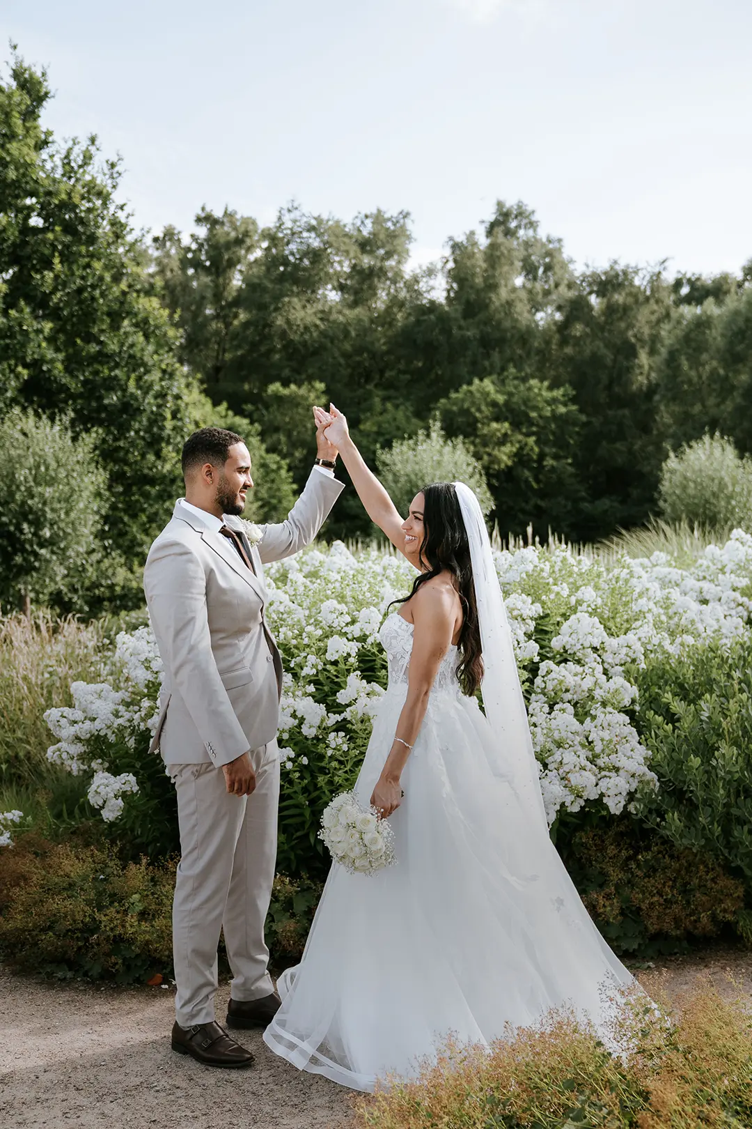 Vertikales Mobil-Header-Bild: Braut und Bräutigam tanzen im blühenden Garten in Kiel – natürliche Hochzeitsfotografie, hochzeitsbilder draußen
