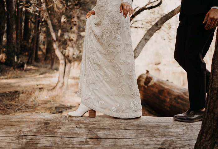 moving Gif of a bride and groom walking on a log in their formals