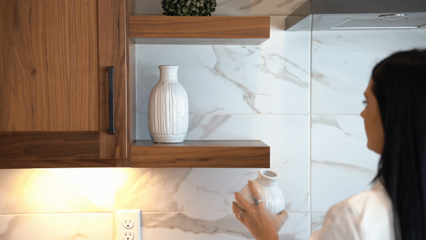 woman's hand putting a vase on a shelf