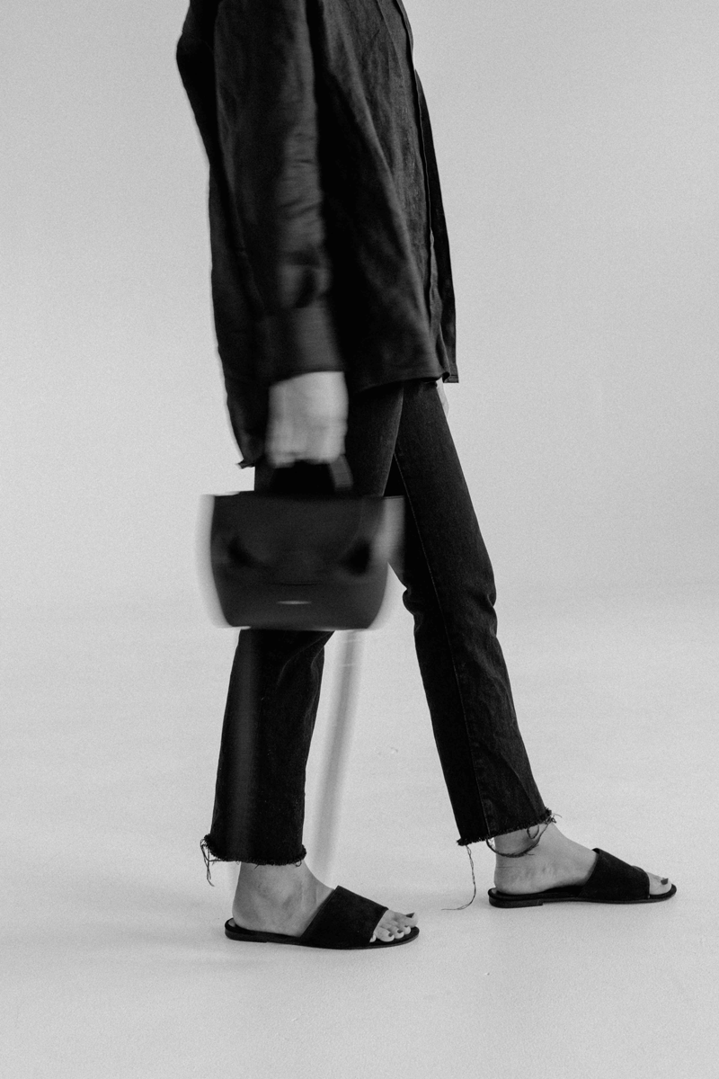 black and white of a woman swinging a purse slowly