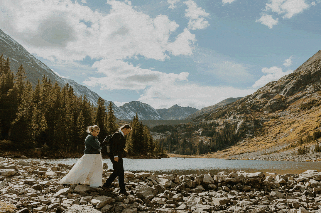 couple walking in front of mountains and lake