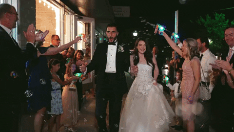bride and groom walking through crowd