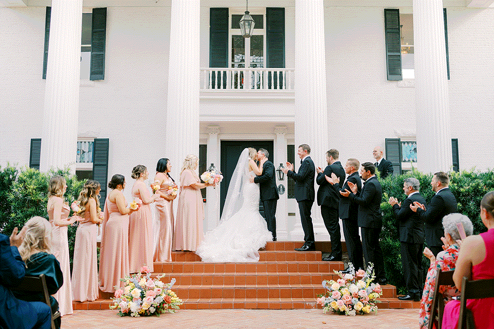 engaged couple dipping in yard with bright pink azalea flowers everywhere, taken by tara paige weddings