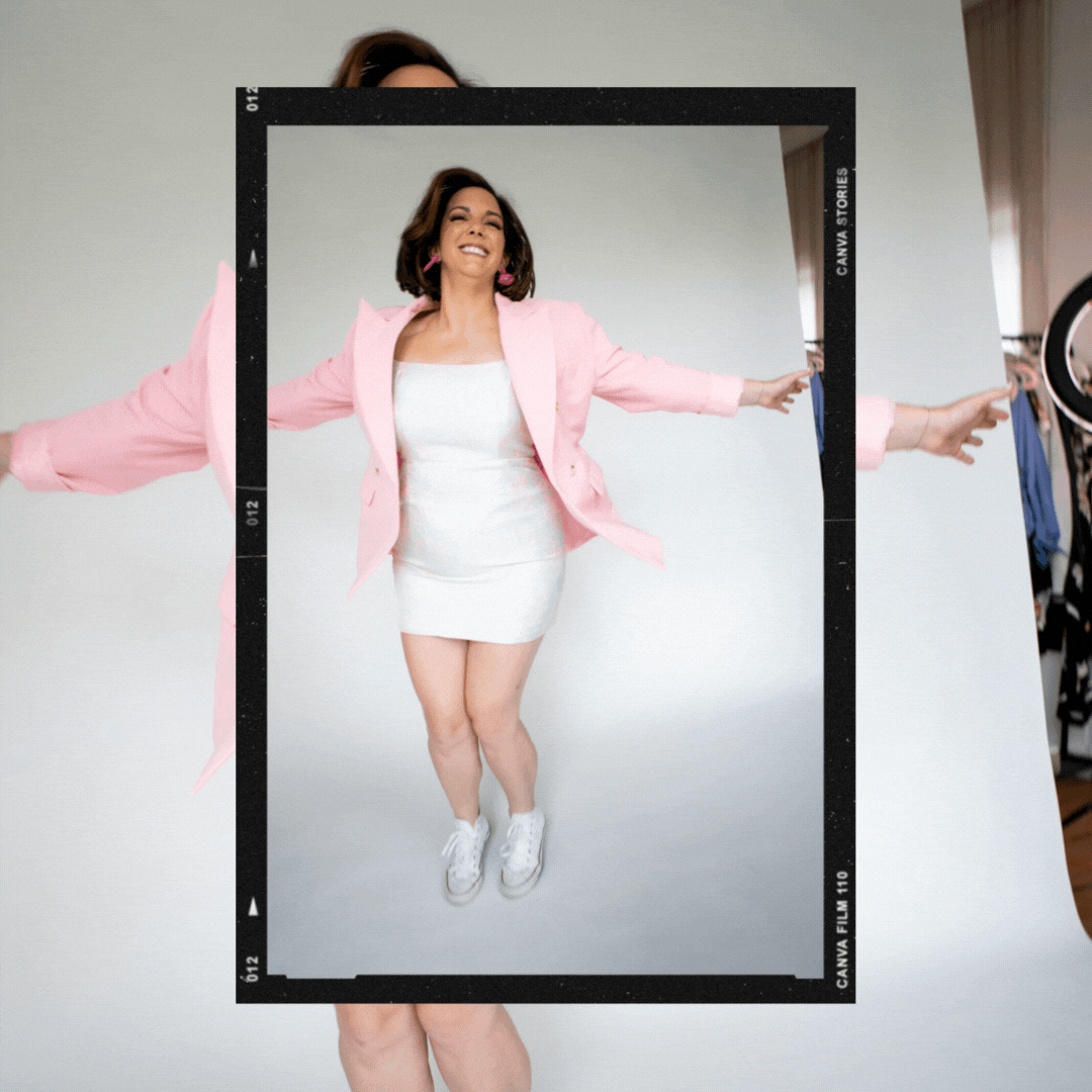 positive female in a pink blazer jumping