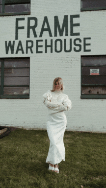 women wearing wedding dresses in front of a frame warehouse