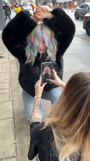 close up of woman with multi-colored hair and fringe jacket