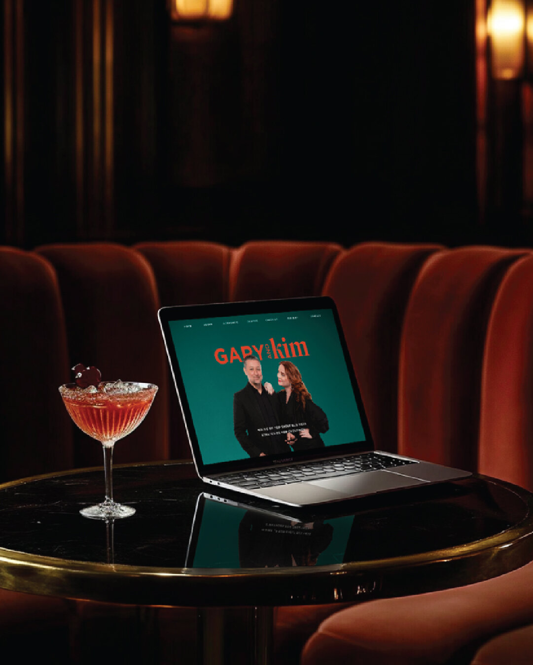 Mockup of Gary and Kim’s homepage on a laptop set against a cocktail lounge backdrop, showing the brand in real-world context.