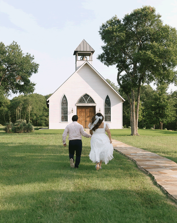 GIF of man and woman holding hands and running toward a white chapel