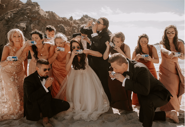 gif of wedding party shotgunning a beer on the beach