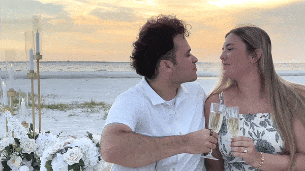 Moving gif of couple kissing over their champagne glasses