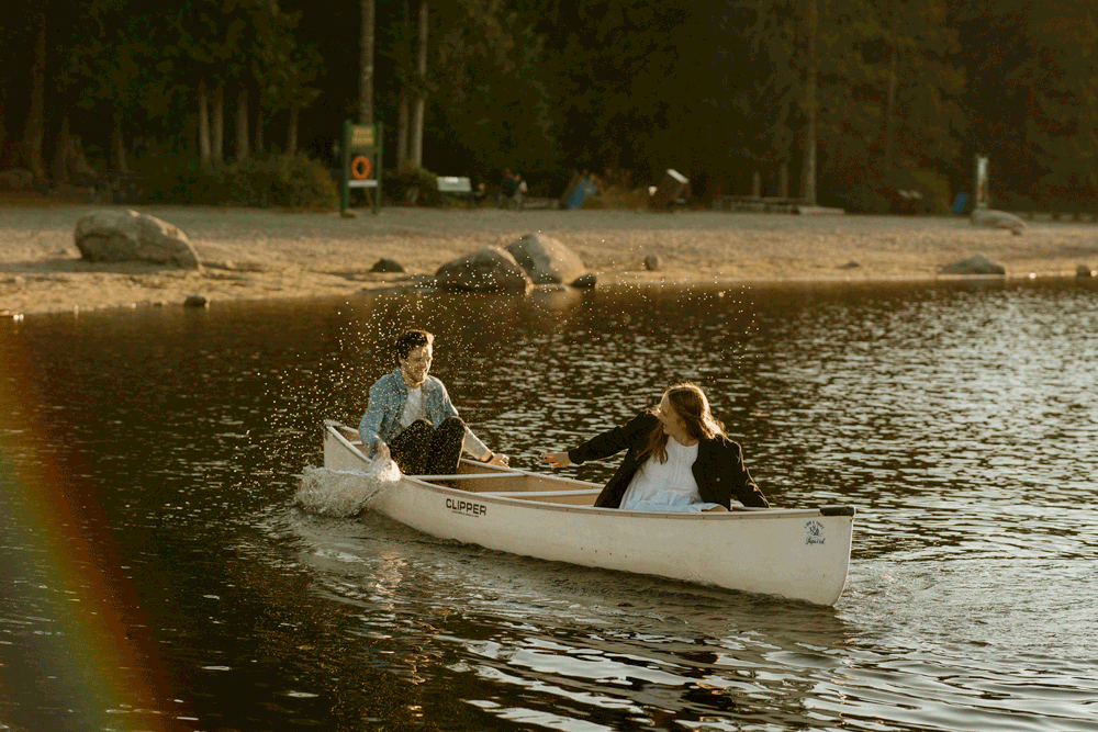 cute engagement photos gif of a girlfriend and boyfriend splashing and laughing in a canoe on a lake