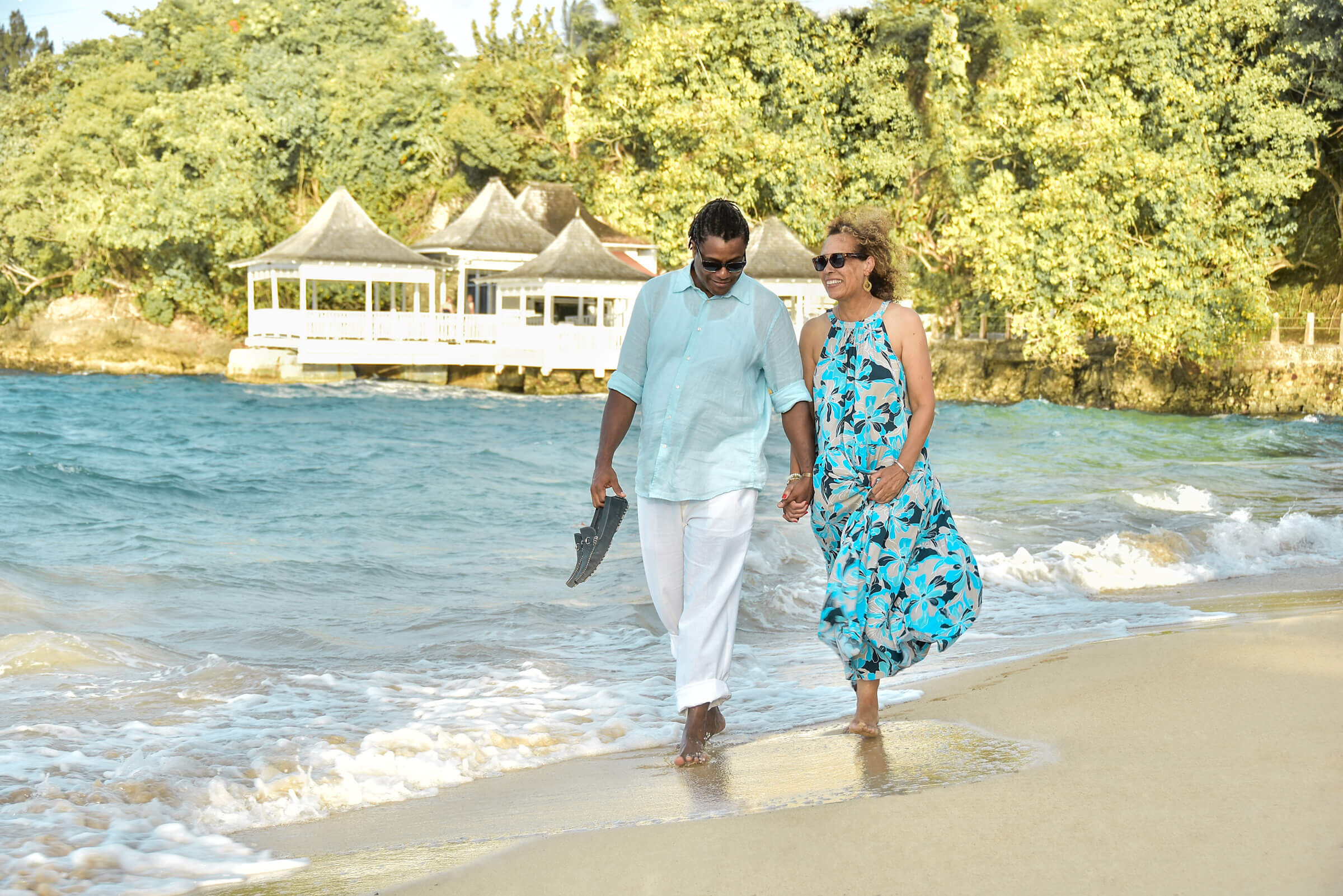 Miami wedding photographer Antonio crutchley and his wife Paula walking on the beach at Couple's Tower Ocho Rios Jamaica