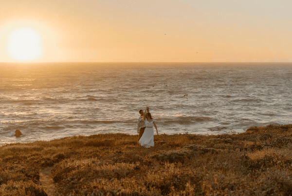 bride and groom dancing by ocean