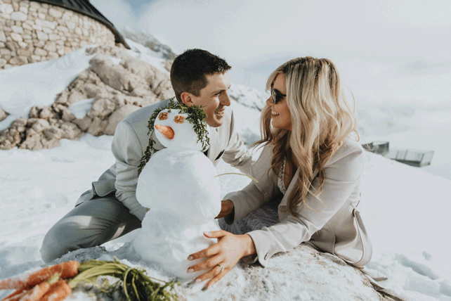 A couple builds a snowman on top of the Zugspitze during their Austria elopement