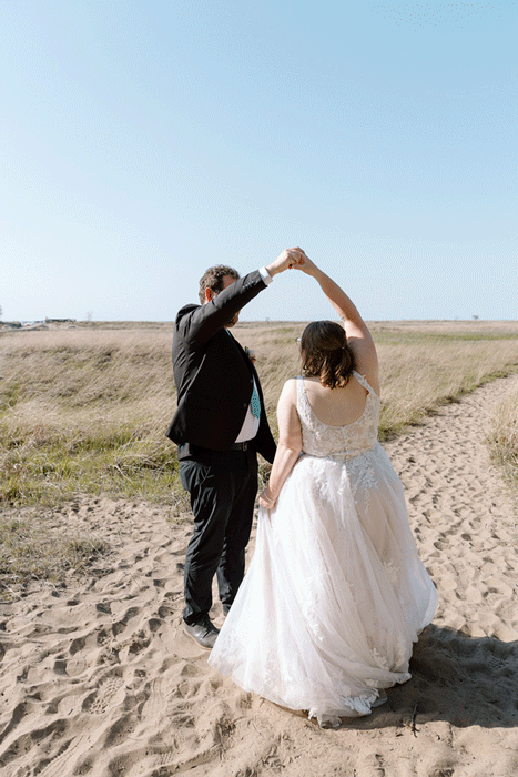 Bride holding up a bouquet of flowers during a beach elopement in Michigan.