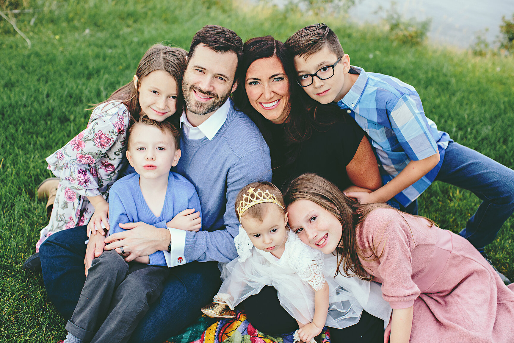 a family of six wearing multiple colors and patterns all complimentary