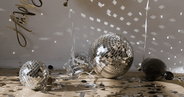 A disco mirror ball reflecting light as it rolls slowly on the floor