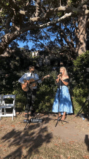 singer in pink dress and guitarist play a wedding reception at Pilu in Sydney's Northern beaches. Photo by FVM photography.