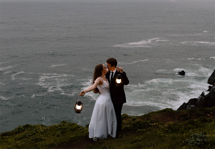 GIF of an elopement couple swinging lanterns near a cliff on the Oregon Coast.