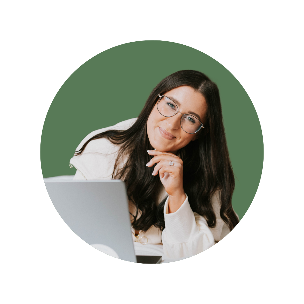 Hannah W., a Web Designer Library member, smiling in front of a laptop, wearing glasses and a cream jacket.