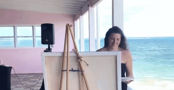 Brin, owner of golden ray studio, painting at a live event in the caribbean