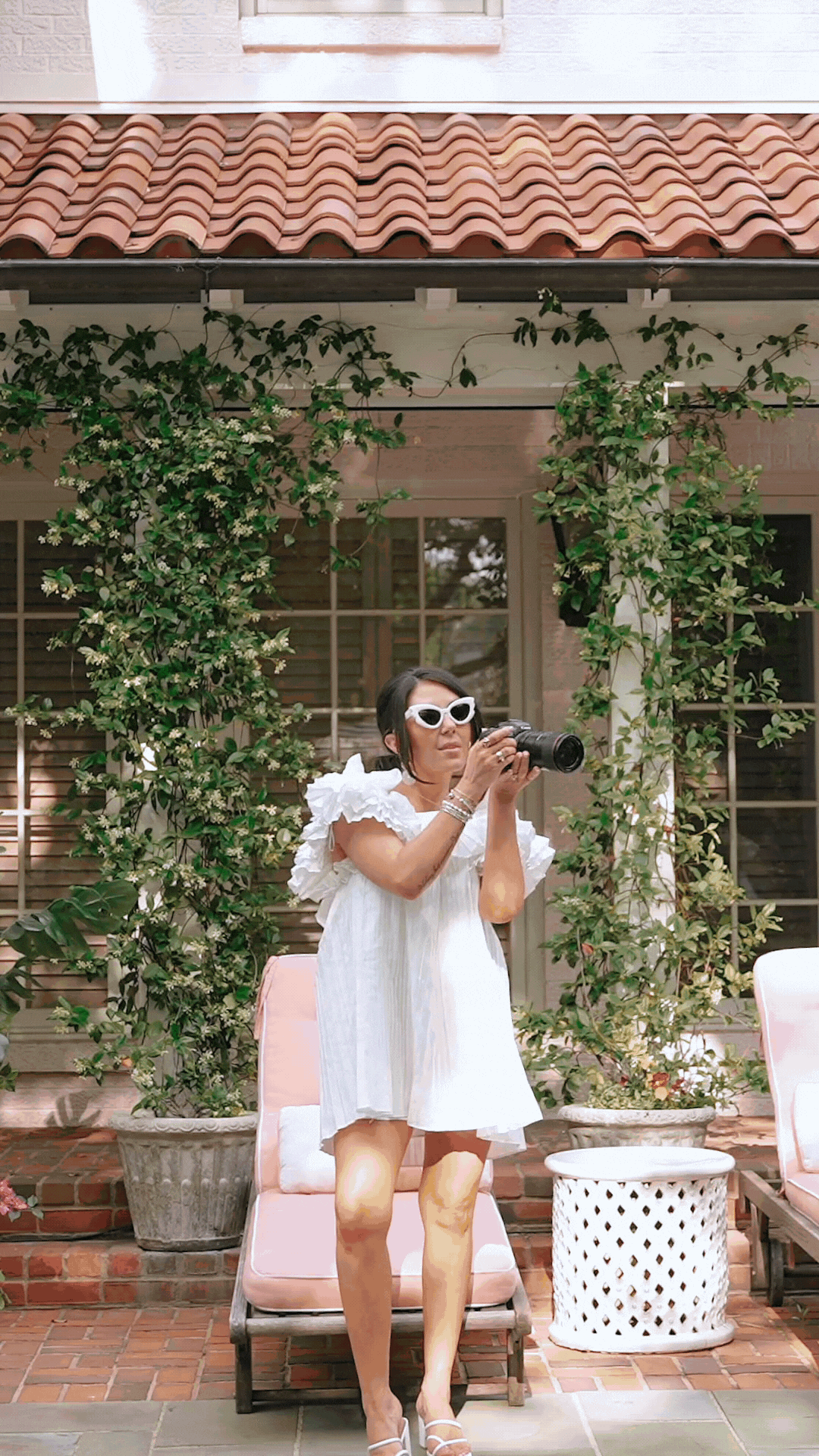 GIF of Cassie Loree holding flowers and a camera