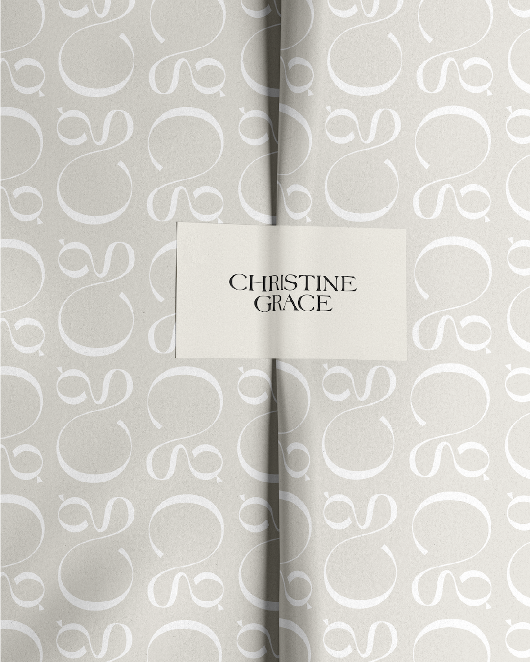 Softly patterned paper wrap with a centered label displaying the Christine Grace logo in sleek black lettering.