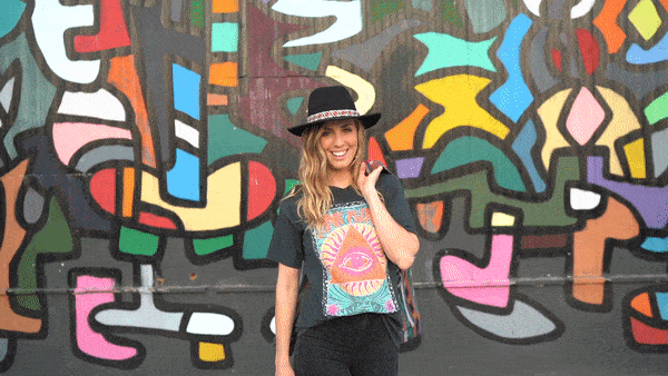 Micaela spinning and laughing in front of a colorful wall at Union Cowork in Encinitas, California