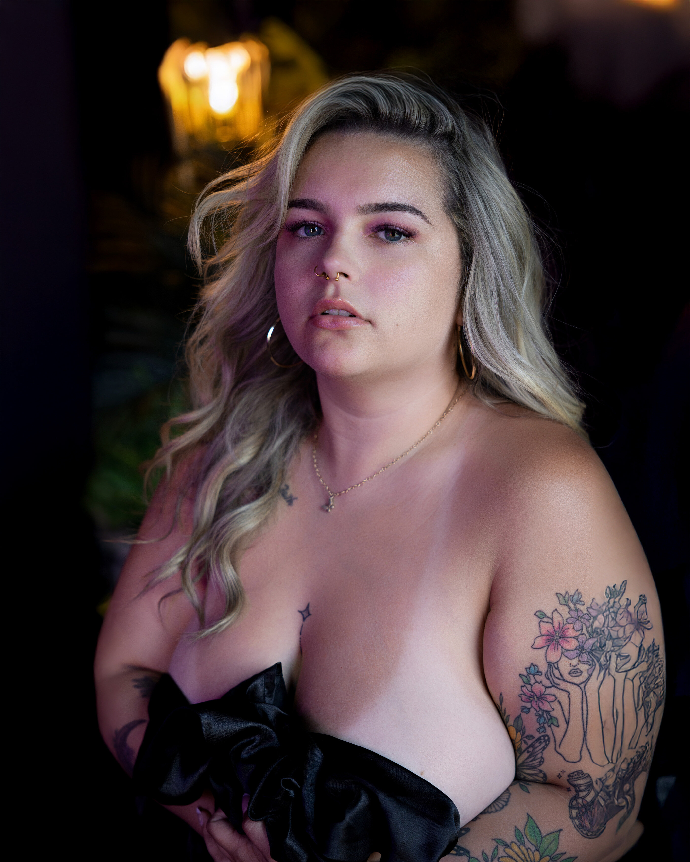 Woman draped with black satin sheet during a DC boudoir photography session